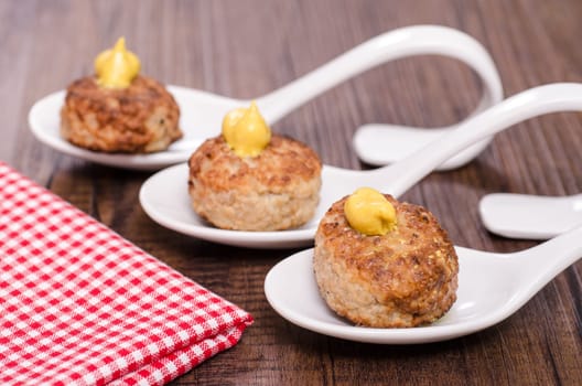 Three meatballs on a spoon of Porzalan as a snack