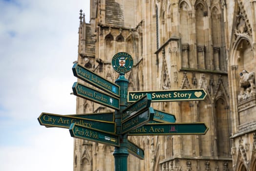 Directions post in York, UK, with city crest and York Minster in detail the background