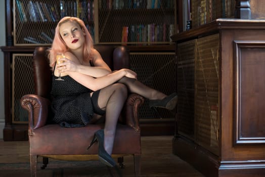Beautiful caucasian woman drinking champagne in old library