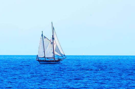 A sailing boat crossing the sea/ocean