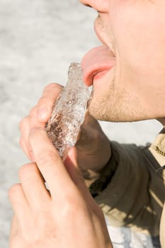 The person has control over a piece of ice and licks it