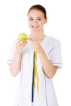 healthy eating or diet concept. smiling woman doctor with a green apple and measuring tape.