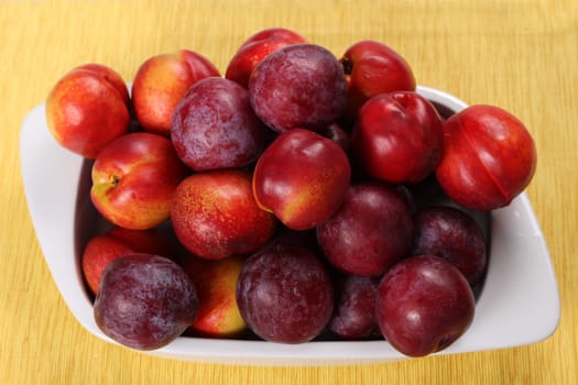 Nectarines and Plums in a ceramic dish.