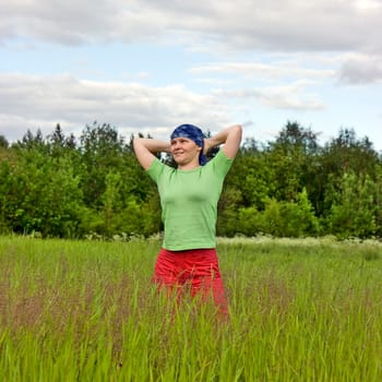 Photo of the smiling girl in the field against wood