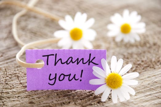 a purple label with Thank you on it and flowers in the background
