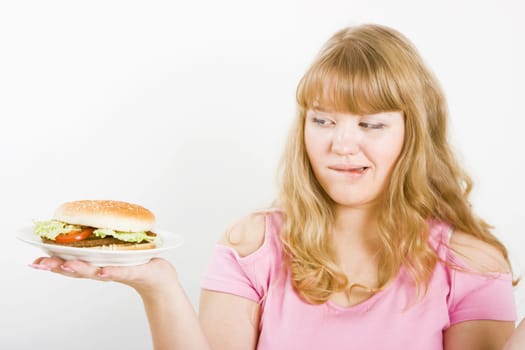 Hungry blonde and a delicious hamburger on a white background