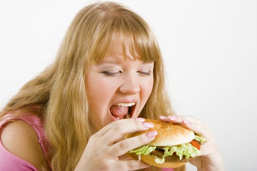 Hungry blonde and a delicious hamburger on a white background