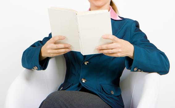 student with a book sitting in white chair