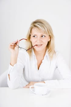 young blonde sitting at the table with a mug