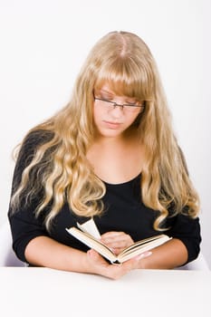 girl with long hair sitting at the table reading