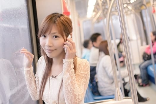 Asian beauty in MRT carriages use her cellphone, Taipei, Taiwan.