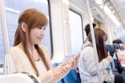 Asian beauty in MRT carriages use her cellphone, Taipei, Taiwan.