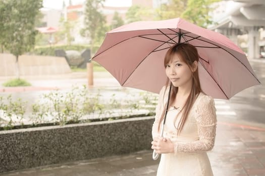 Asian beauty in raining day hold an umbrella in outside, Taipei, Taiwan.