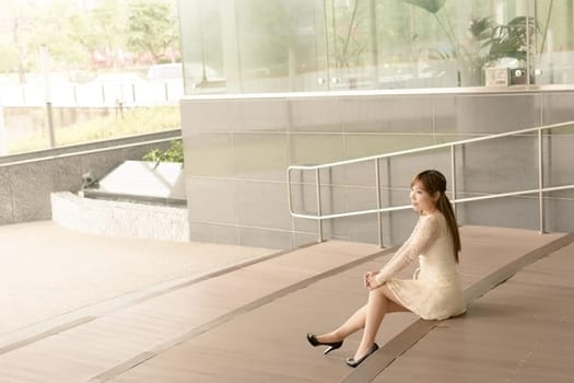Asian beauty sit on ground and look far away in Taipei, Taiwan, Asia.