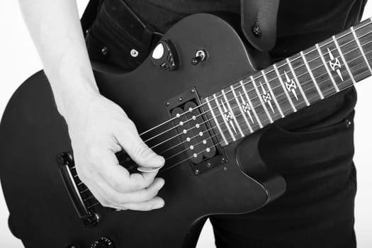 men's hands with a black guitar closeup. monochrome