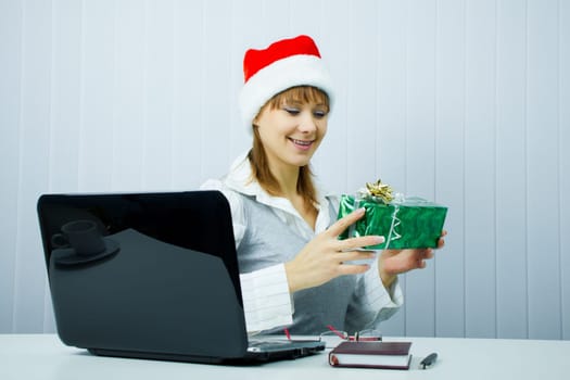 happy business woman in Santa hat with a gift at the office