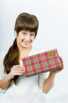 pretty smiling young woman with a gift on a light background. Studio photography