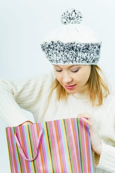 girl in winter hat looks in a package