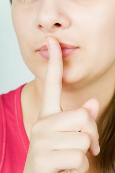 face of a young girl with a finger pressed to his lips