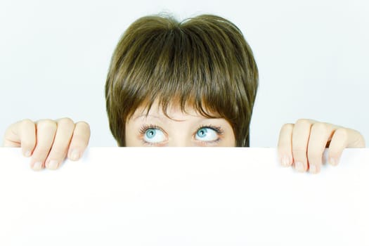 young girl hiding behind a white banner