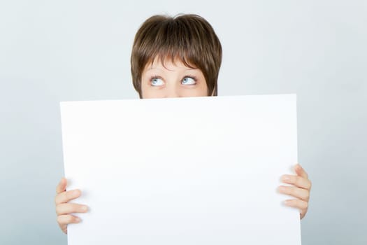 young girl hiding behind a white banner