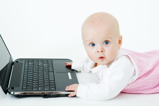 baby with laptop on a white background in studio