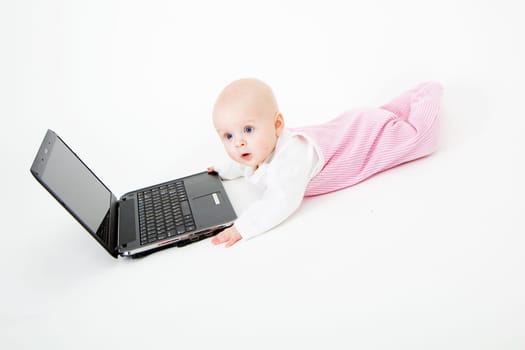 Baby playing with laptop on white background
