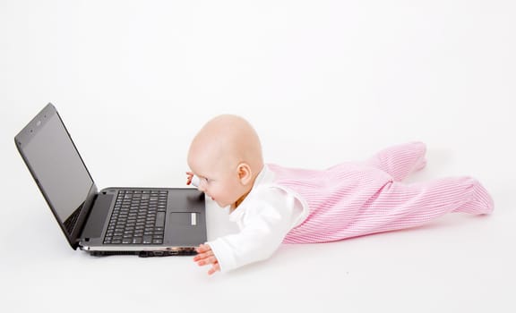 baby with laptop on a white background in studio