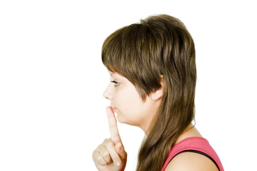 girl keeps the index finger of his lips on an isolated white background