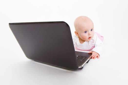 baby with laptop on a white background in studio