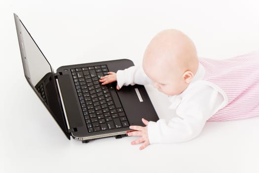 baby with laptop on a white background in studio