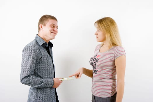 A young couple on a white background. A man holds in his hand the money