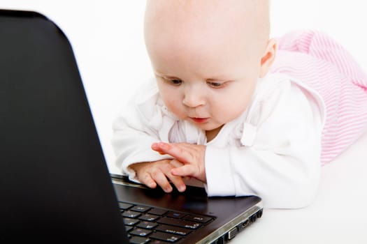 Baby playing with laptop on white background