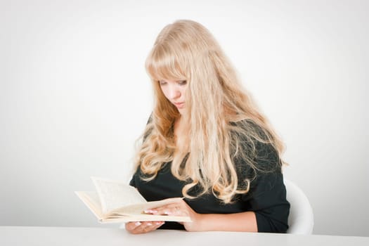 blonde with long beautiful hair, sitting with a book