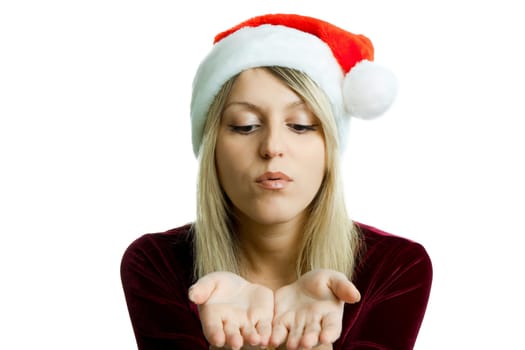 Girl in a Christmas hat blowing in the palm. Isolated background.