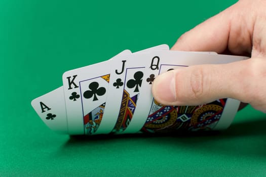 player's hand with the cards on the green game table