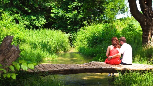 Young couple inlove sitting on a bridge