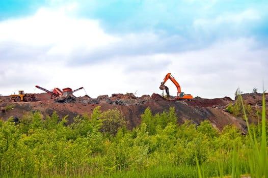 heavy equipment working on the construction of the road on the embankment