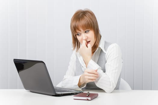 attractive girl anxiously watches the monitor laptop