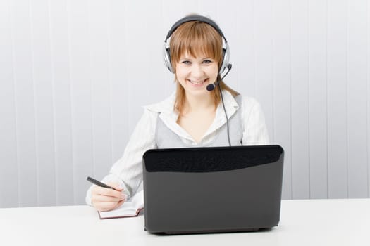 girl with laptop in headphones with a microphone. HotLine