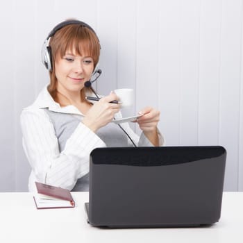 girl-employee hotline is drinking coffee in office