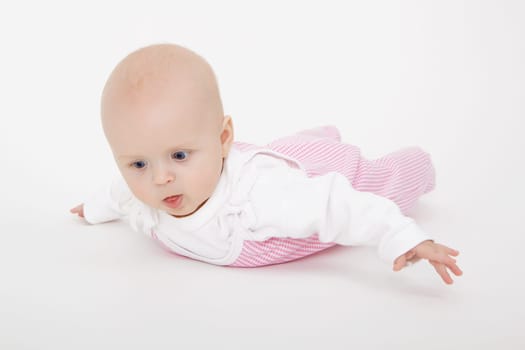 baby lies on a white floor. Studio photography