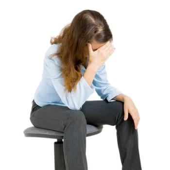 young girl sitting on a chair arm covering her face