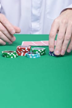 man's hand collects the chips with game table