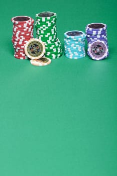 A stack of chips on a green playing a gambling table in a casino