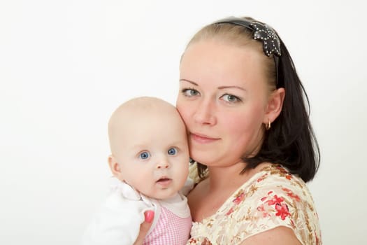 infant in the arms of the mother on a light background