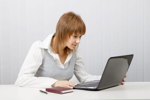 attractive young girl with surprise stares at the monitor laptop