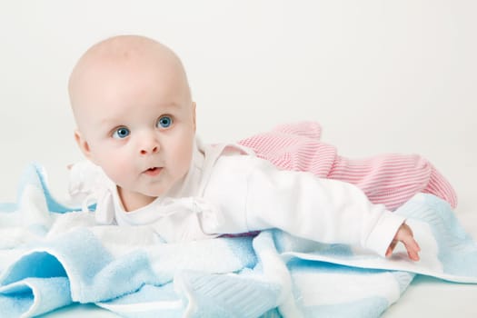little blue-eyed girl with a blue towel. baby. Studio photography