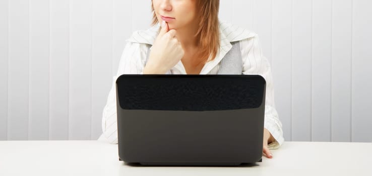 Business pensive woman with a laptop. Office scene.