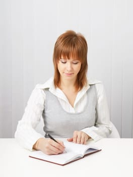 business attractive girl with a notebook and pen in the office.